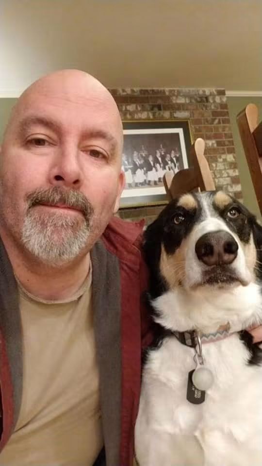 Man and dog posing for a selfie indoors