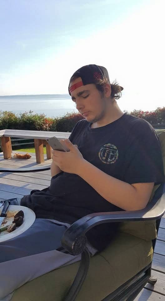 Teenager sitting on a deck overlooking the water