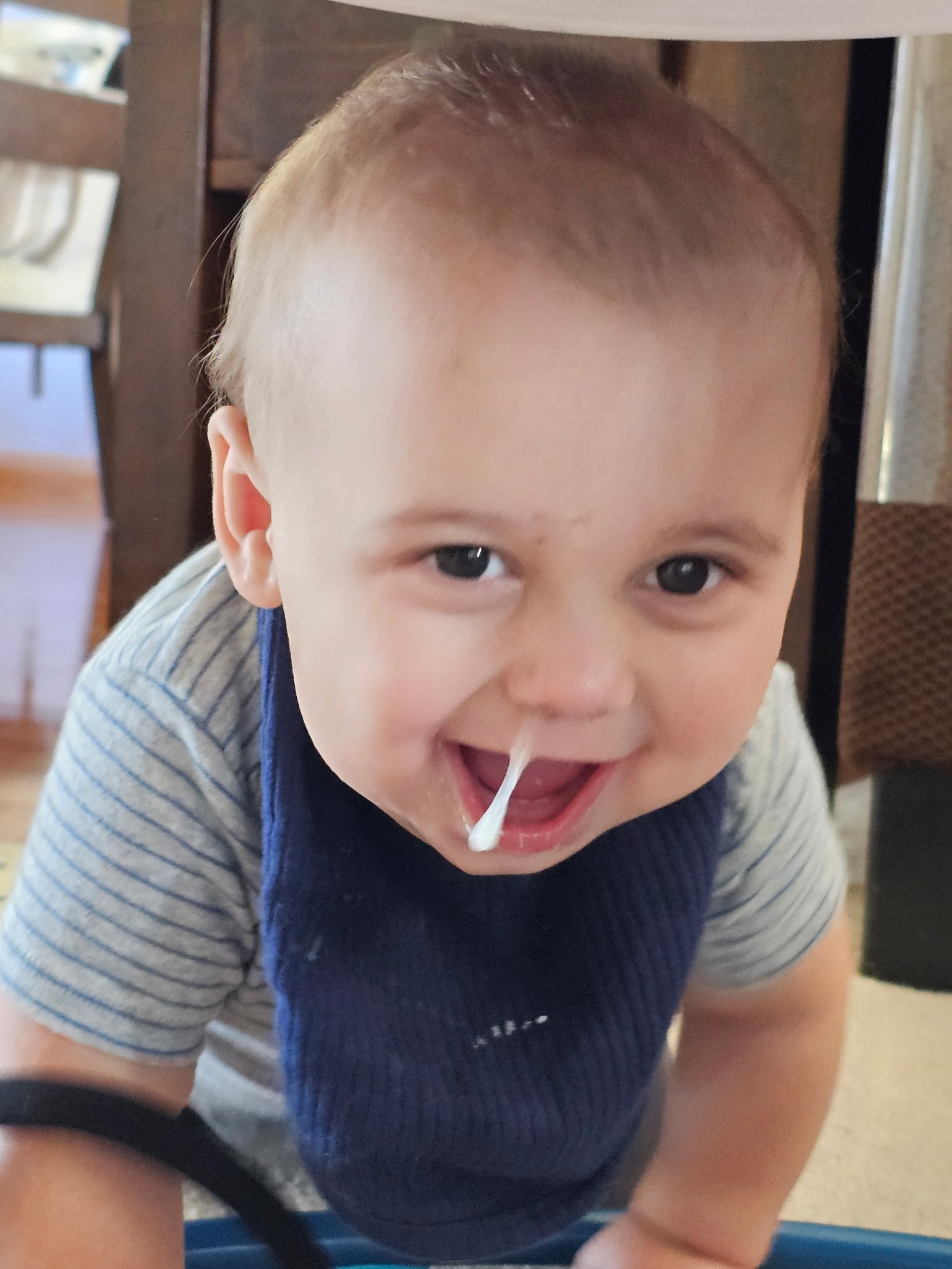 Baby grinning up at the camera with a bib