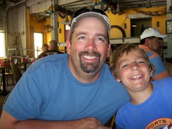Father and young son smiling together at a restaurant