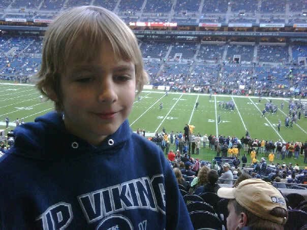 Young boy in a Vikings hoodie at a football stadium