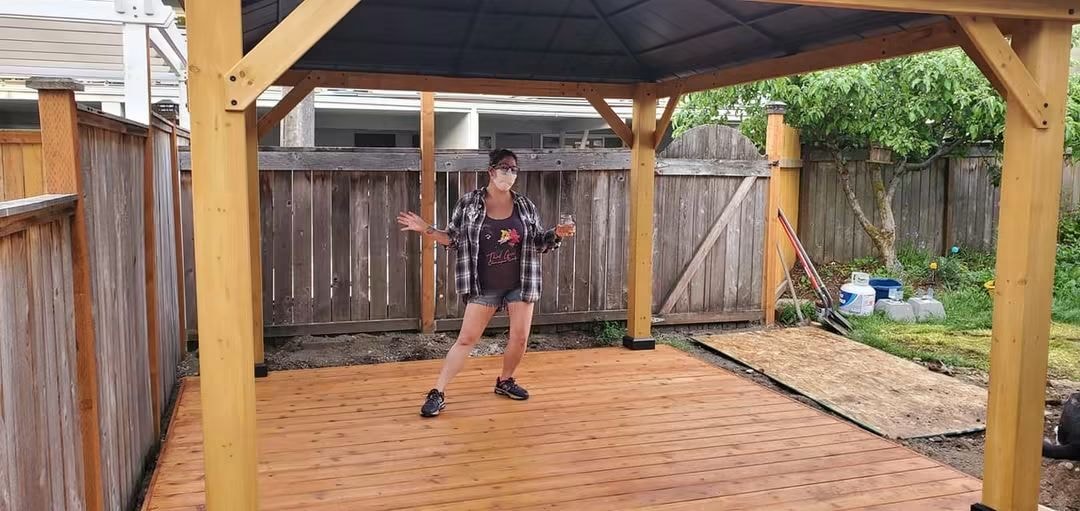Friend posing on a new backyard deck under a gazebo