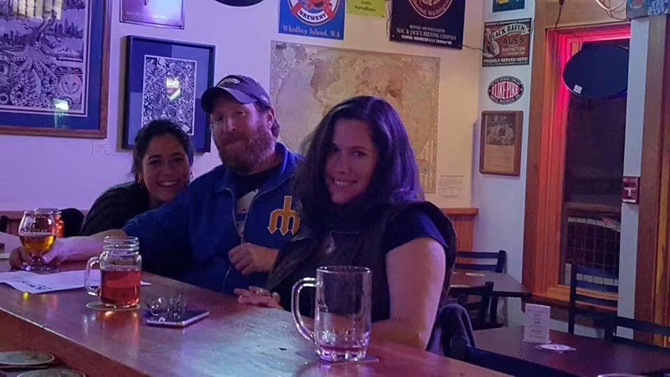 Three friends at a craft beer bar with Whidbey Island brewery signs